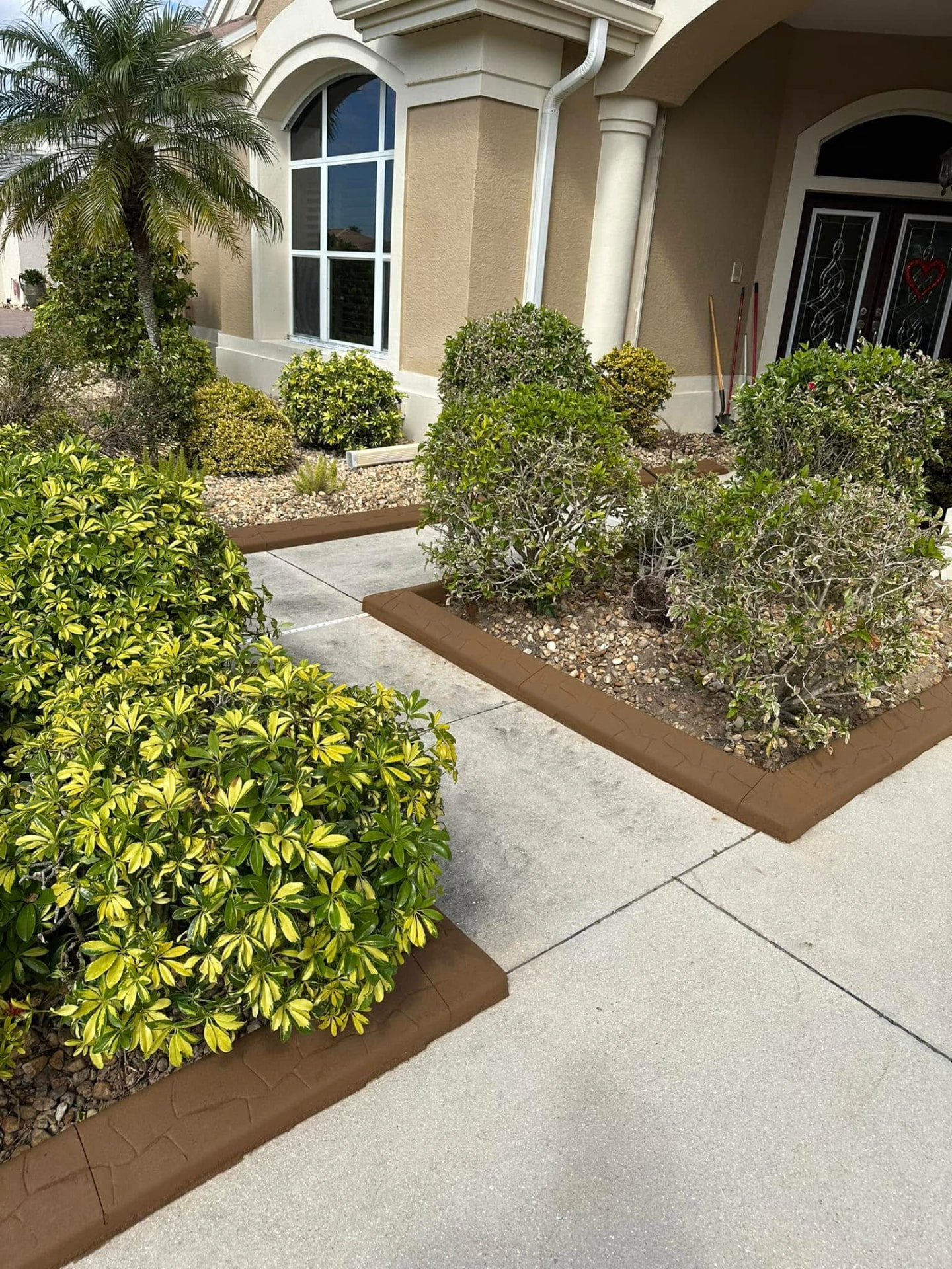 Brown stone-pattern curbing edging shrub beds at a front entry walkway